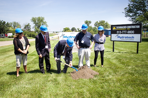Hydrotech executives including, President Pete Jones (middle), dig ground where part of a new 23,000 square foot expansion will be located.