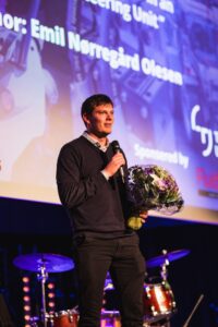 Emil Nørregård Olesen speaking at the SICFP 2023 gala after winning Best Paper Award.