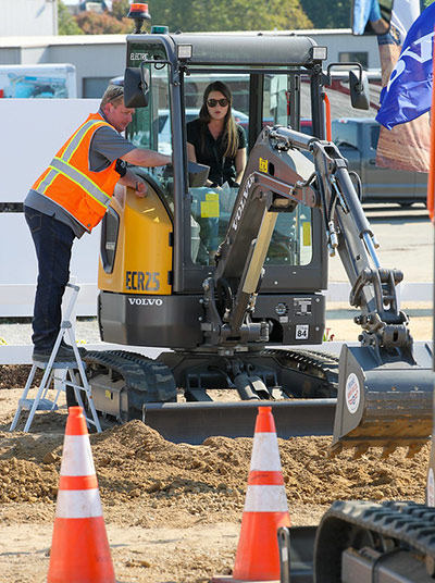 A woman test drives the Volvo ECR25 compact excavator at Utility Expo in 2021.