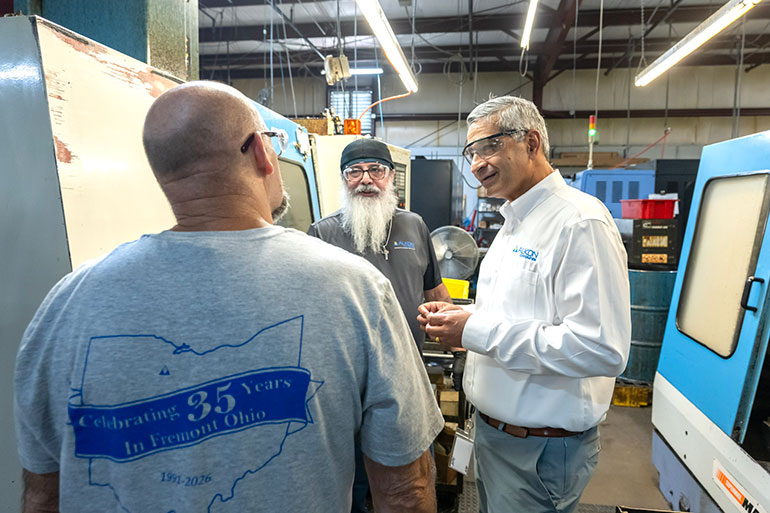 Rahul Deshmukh talks with machining team members Ray Roberts and Steve Chamberlain about Alkon products and manufacturing.