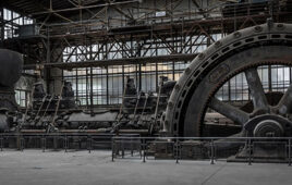 Figure 1. Early electrification of hydraulics started with giant, stationary steam engines rotating flywheels, which in turn drove a downstream array of shafts, pulleys, and leather belts to power lathes, drills, mills, or even hydraulic pumps.